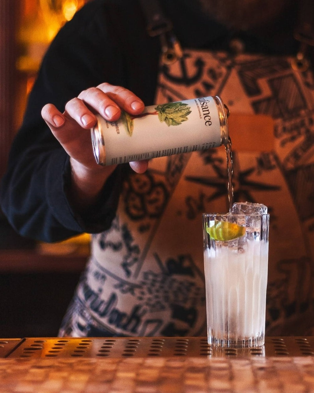 A Cocktail Barman pouring a can of with a can of Premium Mint, Cucumber and Chilli botanical drink from Scotland-based drinks start-up brand Nuisance drinks in to a cocktail of Vodka and lime Juice