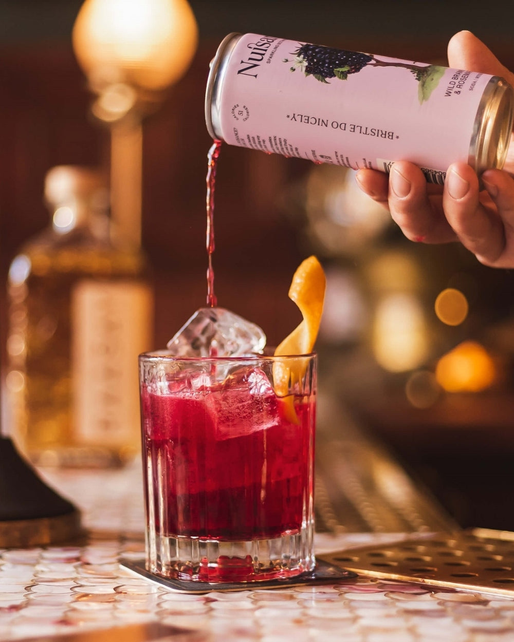 A cold refreshing glass of gin is topped with a refreshing can of premium Bramble and Rosemary botanical soft drink from Scotland-based drinks start-up brand  Nuisance drinks.