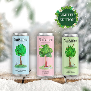 Three cans of Nusance drinks with tree illustrations on a snowy background