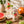 A can of Nuissance Cranberry Infused Water, Pink Grapefruit & Basil flavor, displayed next to a glass of sparkling water garnished with a grapefruit slice and basil leaves on a rustic wooden table, surrounded by fresh grapefruits and basil.