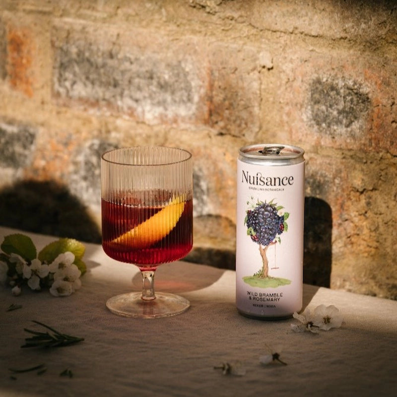 Nuisance drinks natural, low-calorie, low-sugar premium Bramble & Rosemary  botanical soft drink served in a cold glass over brunch